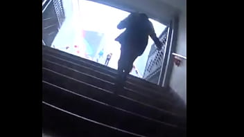 Nalgona en medias negras en escaleras del metro